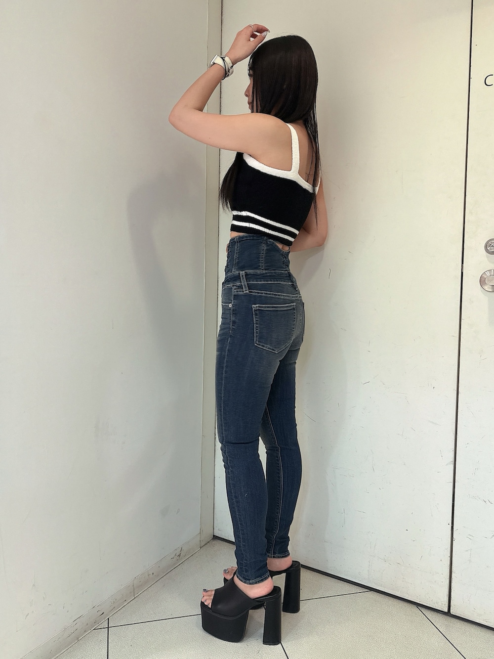 ブルー系のデニムパンツ、ブラック系のキャミソール、ブラック系のサンダルを着用したレディースの春コーディネートの2枚目の写真