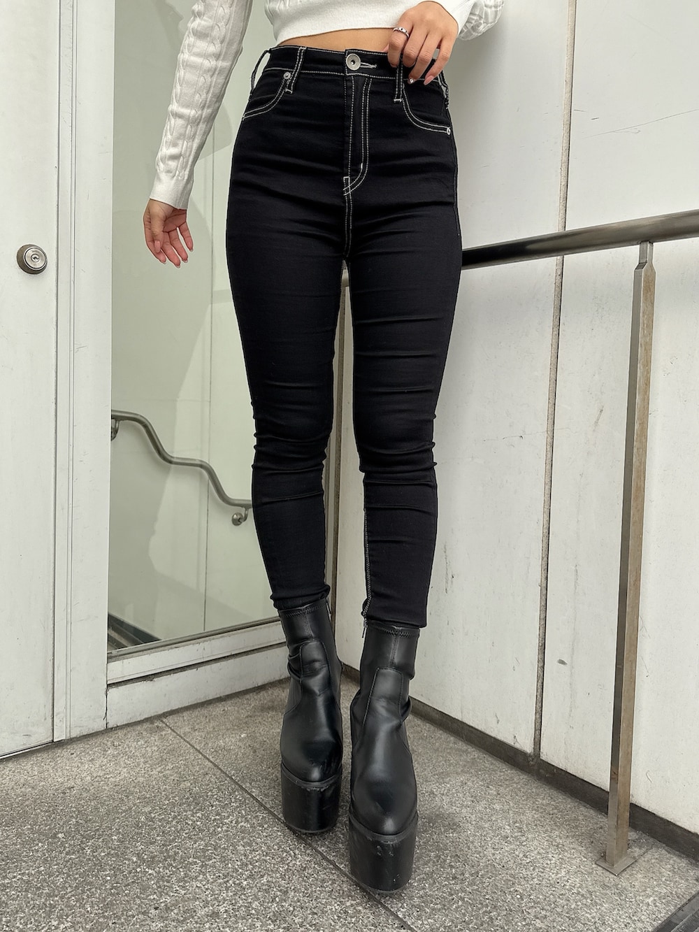 ブラック系のブルゾン、ブラック系のデニムパンツ、ブラック系のブーツを着用したレディースの冬コーディネートの9枚目の写真