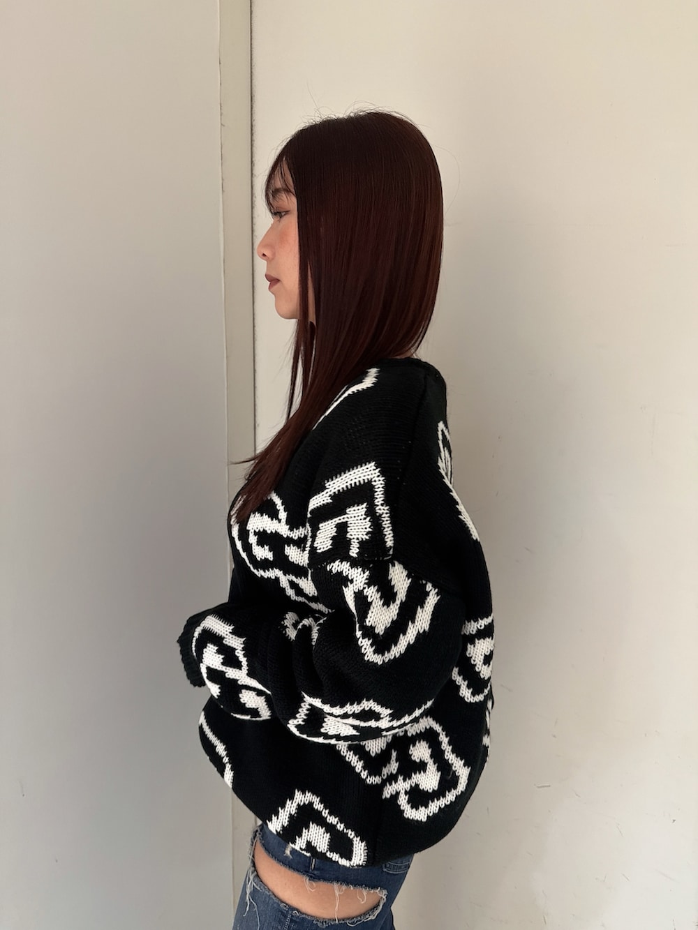 ブラック系のブーツ、ブルー系のデニムパンツ、ブラック系のニット/セーターを着用したレディースの秋コーディネートの5枚目の写真