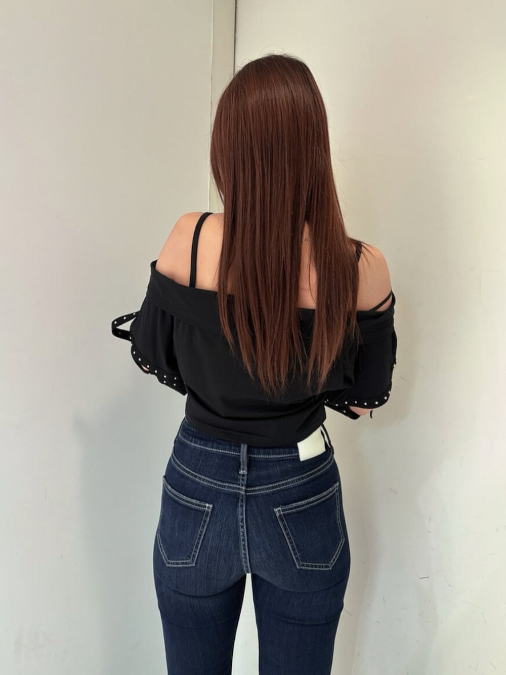 ブルー系のデニムパンツ、ブラック系のサンダル、ブラック系のTシャツ/カットソーを着用したレディースの春コーディネートの6枚目の写真