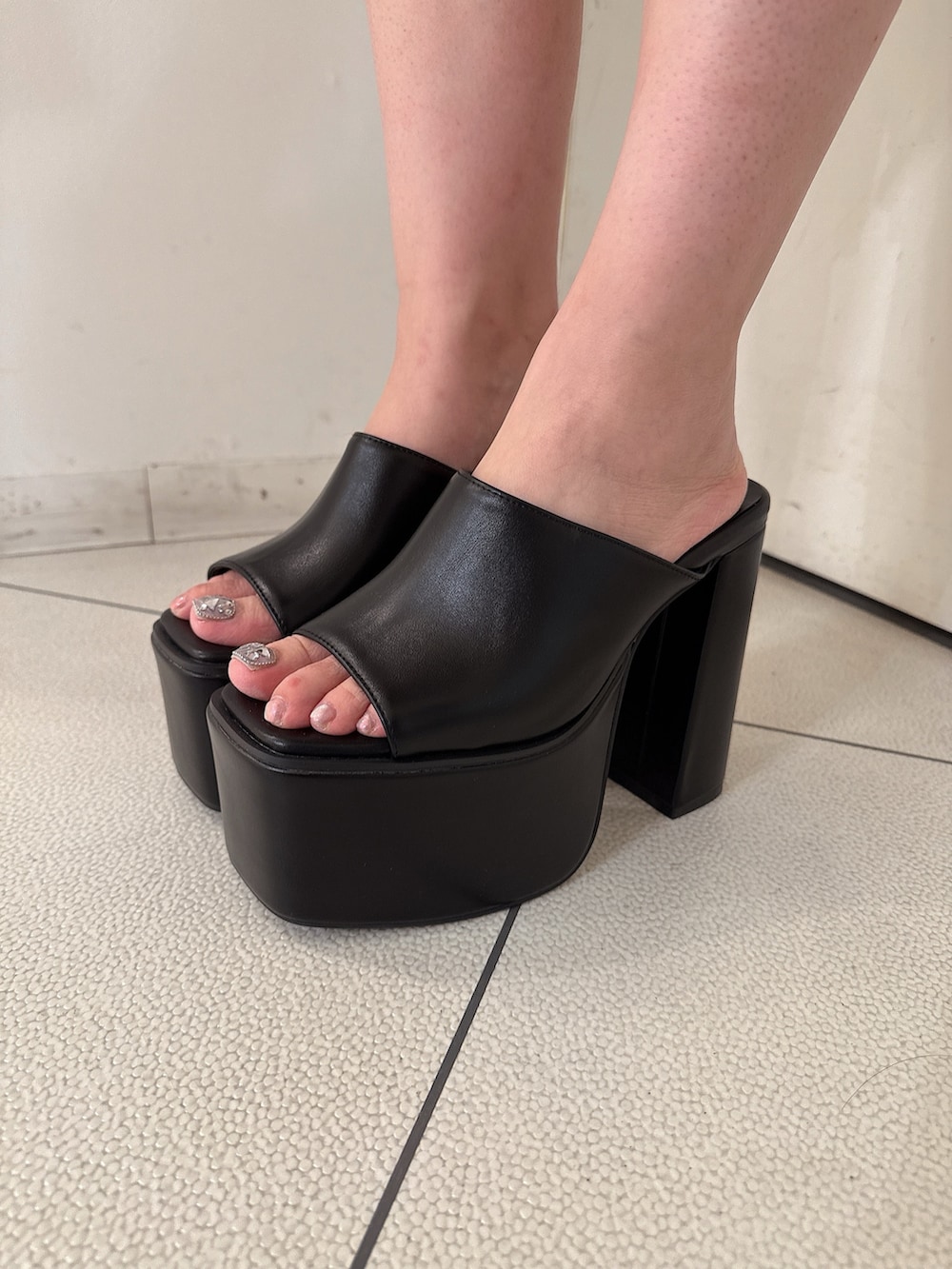 ブラック系のサンダル、ホワイト系のスウェットパンツ、ホワイト系のキャミソールを着用したレディースの夏コーディネートの9枚目の写真