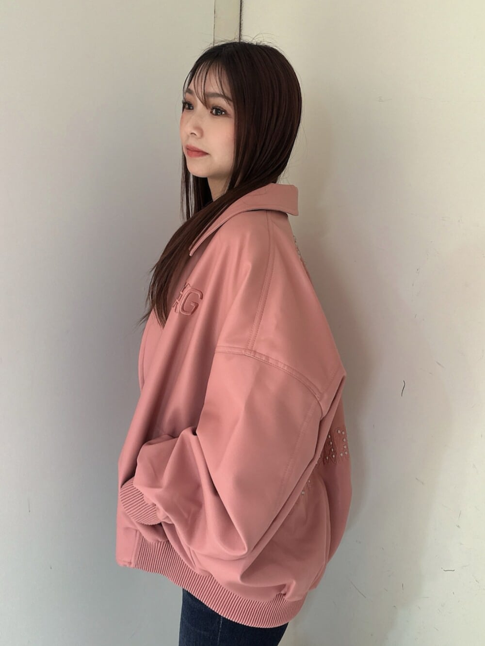 ブルー系のデニムパンツ、ブラック系のサンダル、ピンク系のブルゾンを着用したレディースの春コーディネートの5枚目の写真