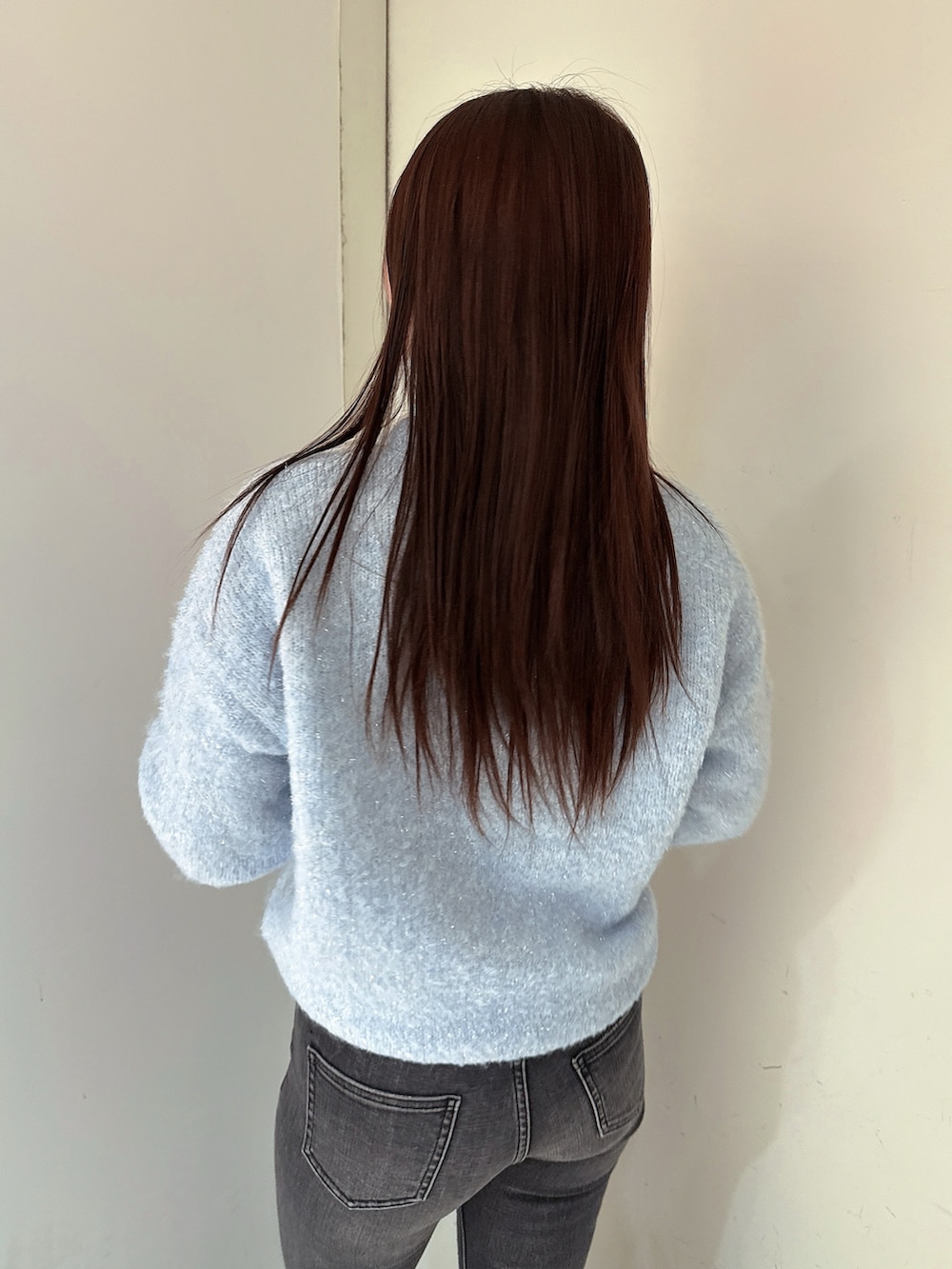 ブラック系のブーツ、ブルー系のニット/セーター、ブラック系のデニムパンツを着用したレディースの冬コーディネートの6枚目の写真