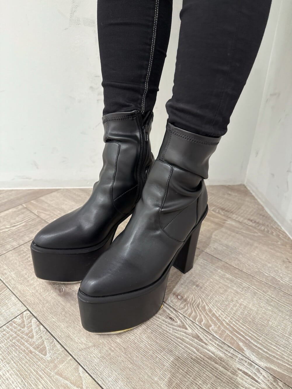 ブラック系のデニムパンツ、ホワイト系のスウェット、ブラック系のブーツを着用したレディースの夏コーディネートの8枚目の写真