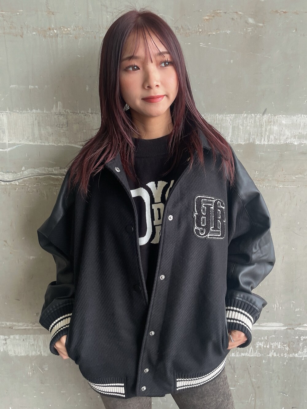 ブラック系のスタジャン、ブラック系のニット/セーター、ブラック系のデニムパンツを着用したレディースの秋コーディネートの4枚目の写真