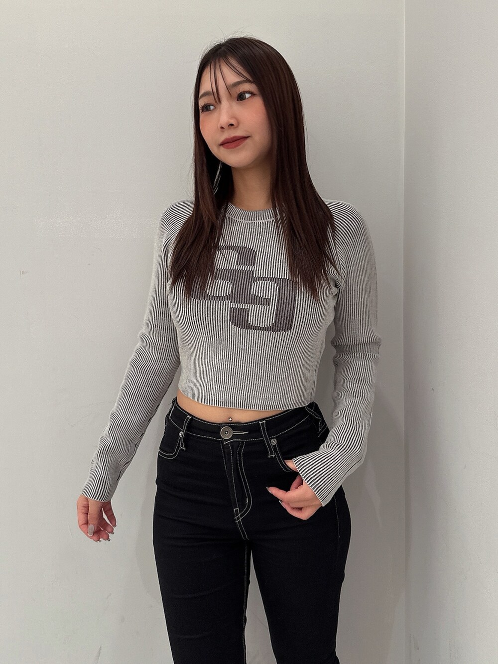 ブラック系のニット/セーター、ブラック系のデニムパンツ、ブラック系のブーツを着用したレディースの夏コーディネートの4枚目の写真