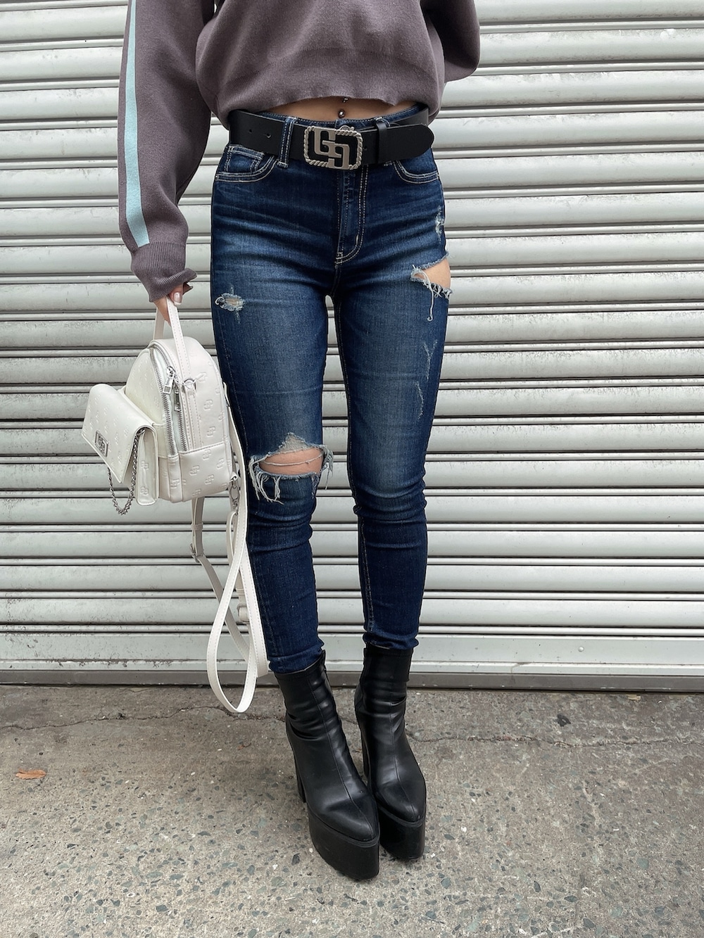 グレー系のニット/セーター、ブルー系のデニムパンツ、ブラック系のブーツを着用したレディースの冬コーディネートの7枚目の写真