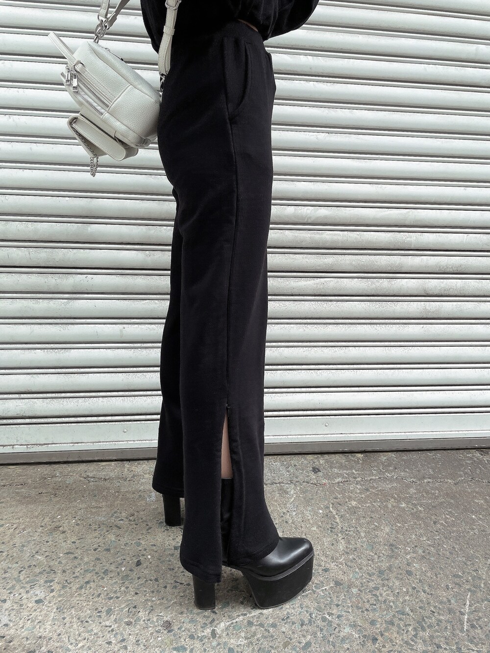 ブラック系のパーカー、ブラック系のスウェットパンツ、ホワイト系のバックパック/リュックを着用したレディースの冬コーディネートの4枚目の写真