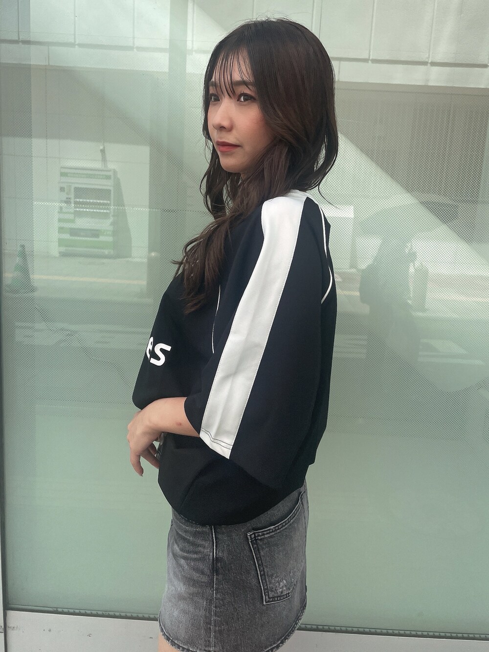 ブラック系のデニムスカート、ブラック系のTシャツ/カットソー、ブラック系のサンダルを着用したレディースの夏コーディネートの5枚目の写真