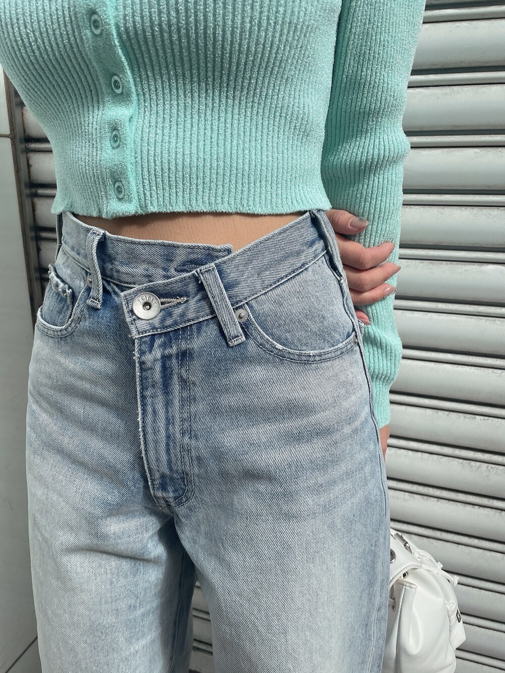 グリーン系のカーディガン/ボレロ、ブルー系のデニムパンツ、ホワイト系のバックパック/リュックを着用したレディースの冬コーディネートの8枚目の写真