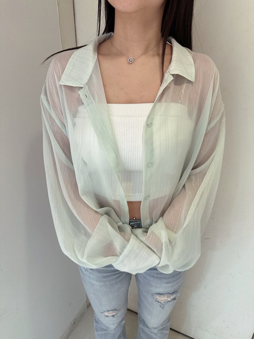 ブルー系のデニムパンツ、グリーン系のシャツ/ブラウス、ホワイト系のチューブトップを着用したレディースの春コーディネートの7枚目の写真