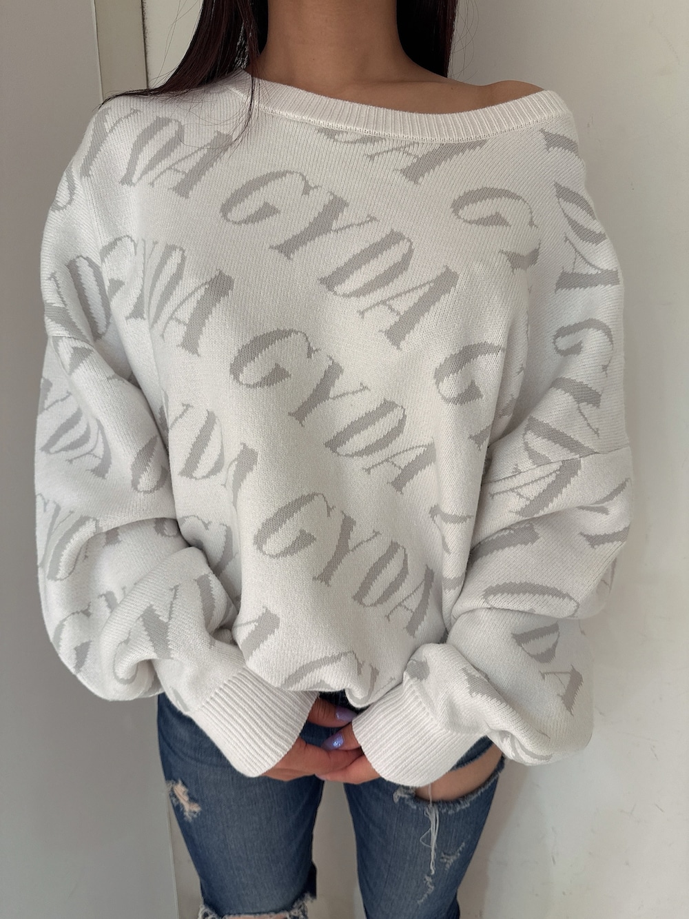 ホワイト系のニット/セーター、ブルー系のデニムパンツ、ブラック系のブーツを着用したレディースの秋コーディネートの7枚目の写真