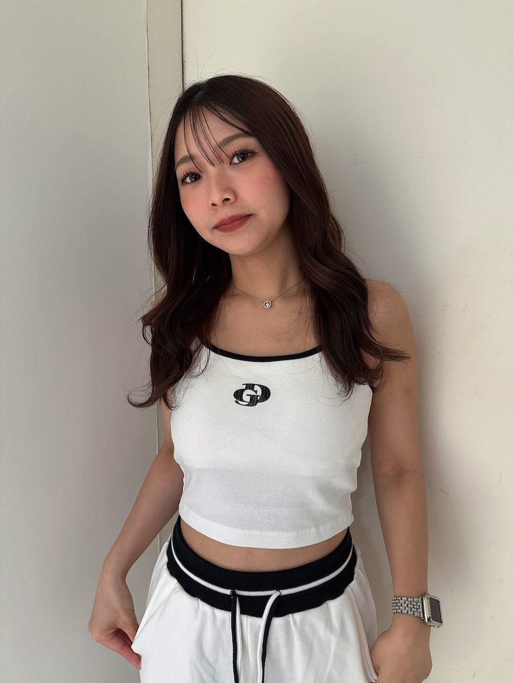 ブラック系のサンダル、ホワイト系のスウェットパンツ、ホワイト系のキャミソールを着用したレディースの夏コーディネートの4枚目の写真