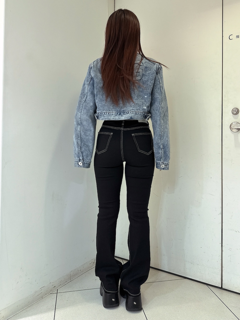 ブラック系のデニムパンツ、ブルー系のデニムジャケット、ブラック系のサンダルを着用したレディースの春コーディネートの3枚目の写真