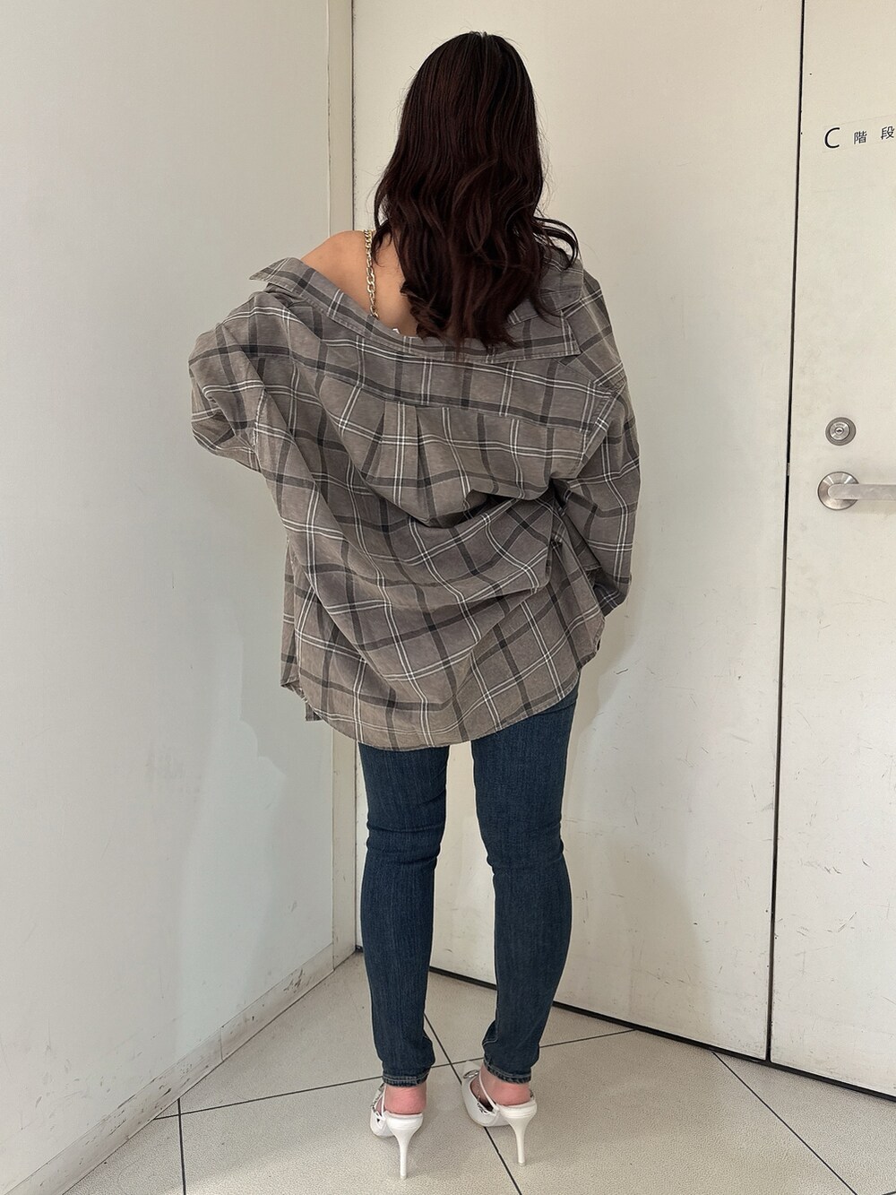 ホワイト系のキャミソール、グレー系のシャツ/ブラウス、ブルー系のデニムパンツを着用したレディースの春コーディネートの3枚目の写真