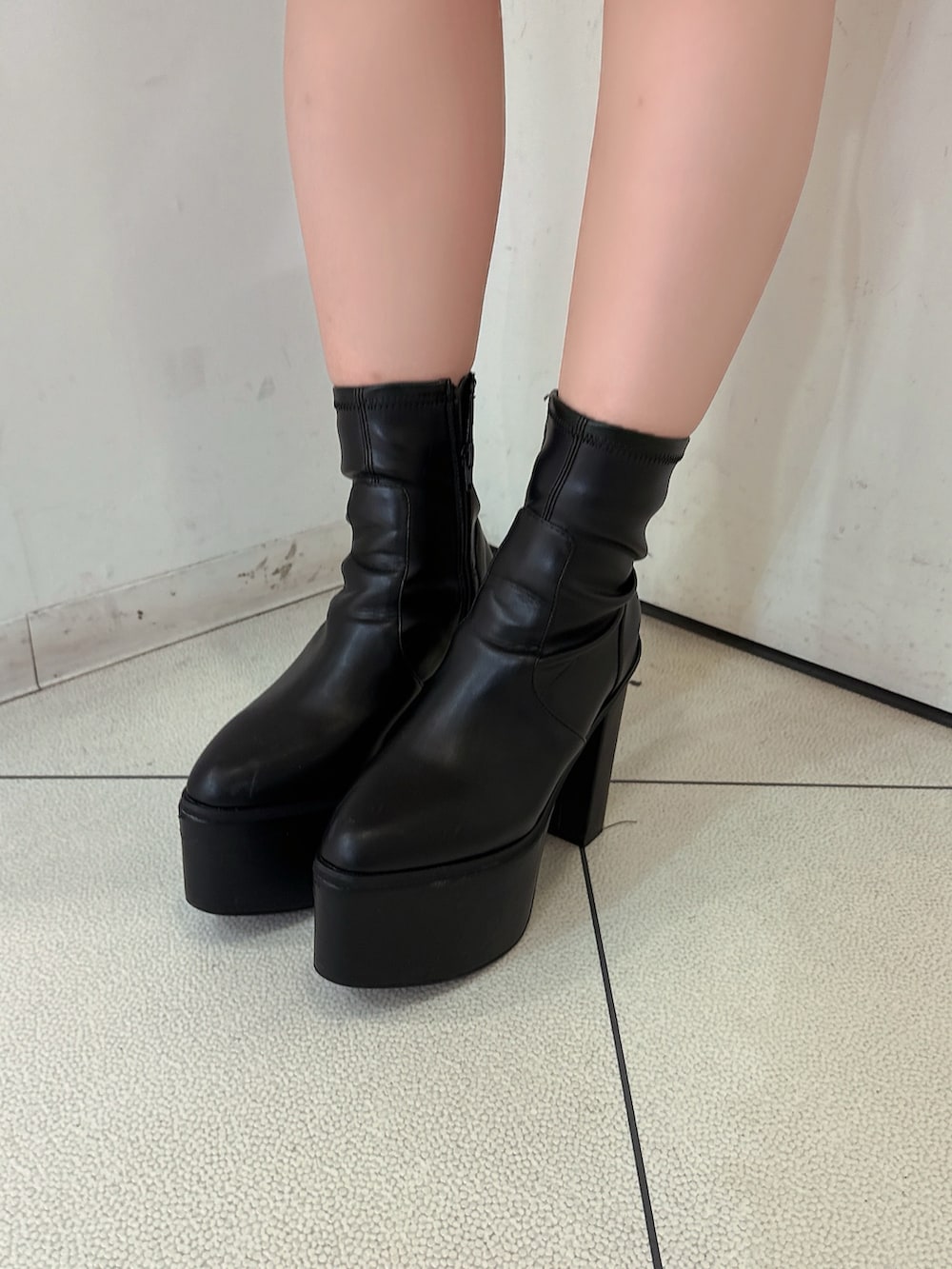 グレー系のデニムパンツ、ブラック系のブーツ、ホワイト系のニット/セーターを着用したレディースの秋コーディネートの9枚目の写真