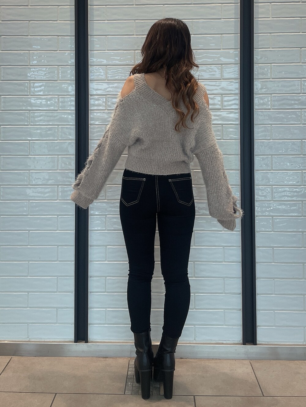 ベージュ系のニット/セーター、ブラック系のデニムパンツ、ブラック系のブーツを着用したレディースの秋コーディネートの3枚目の写真