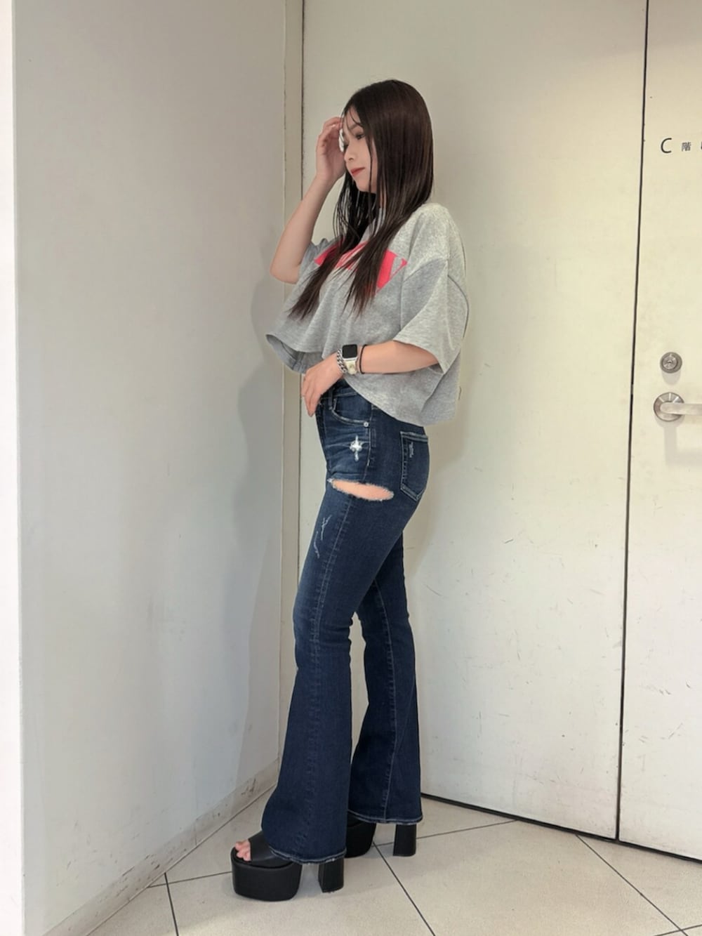 ブルー系のデニムパンツ、ブラック系のサンダル、グレー系のTシャツ/カットソーを着用したレディースの夏コーディネートの2枚目の写真