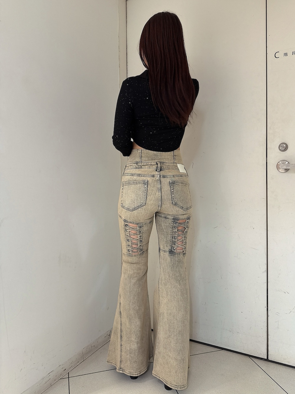 ブラック系のTシャツ/カットソー、ブルー系のデニムパンツ、ブラック系のブーツを着用したレディースの秋コーディネートの3枚目の写真