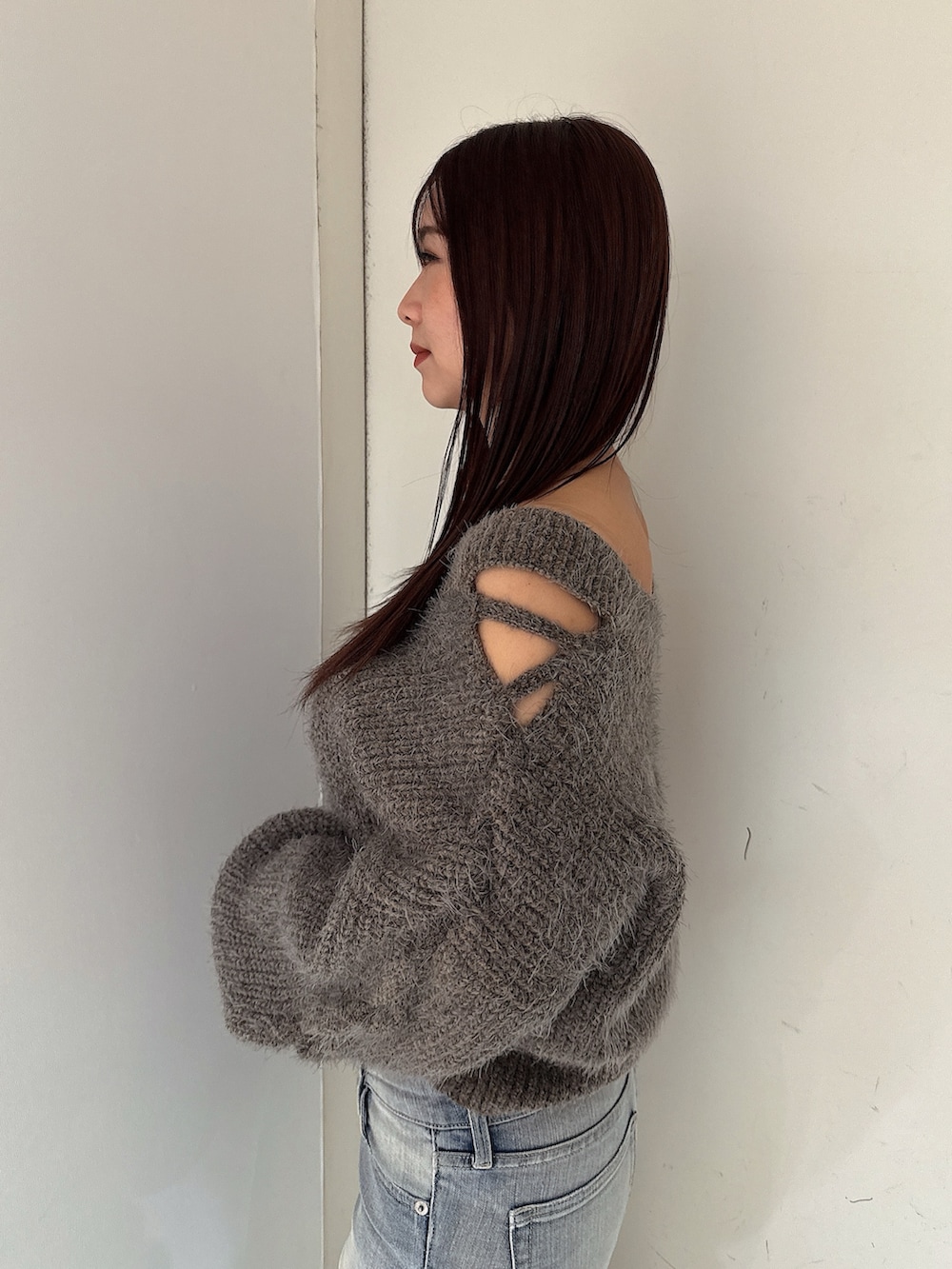 グレー系のニット/セーター、ブルー系のデニムパンツ、ブラック系のブーツを着用したレディースの秋コーディネートの5枚目の写真