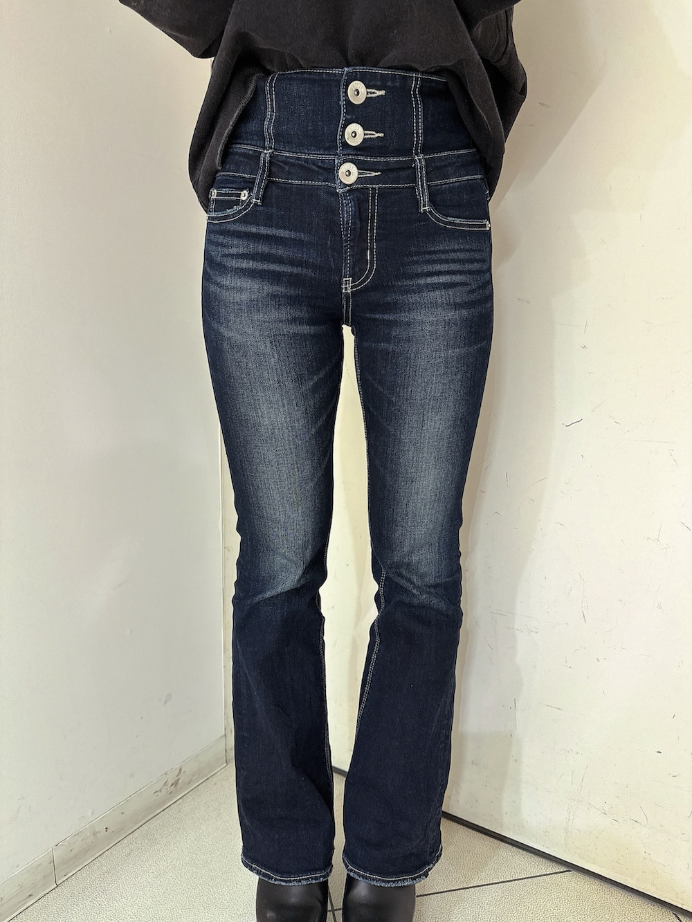 ブルー系のデニムパンツ、ブラック系のスウェット、ブラック系のブーツを着用したレディースの冬コーディネートの9枚目の写真