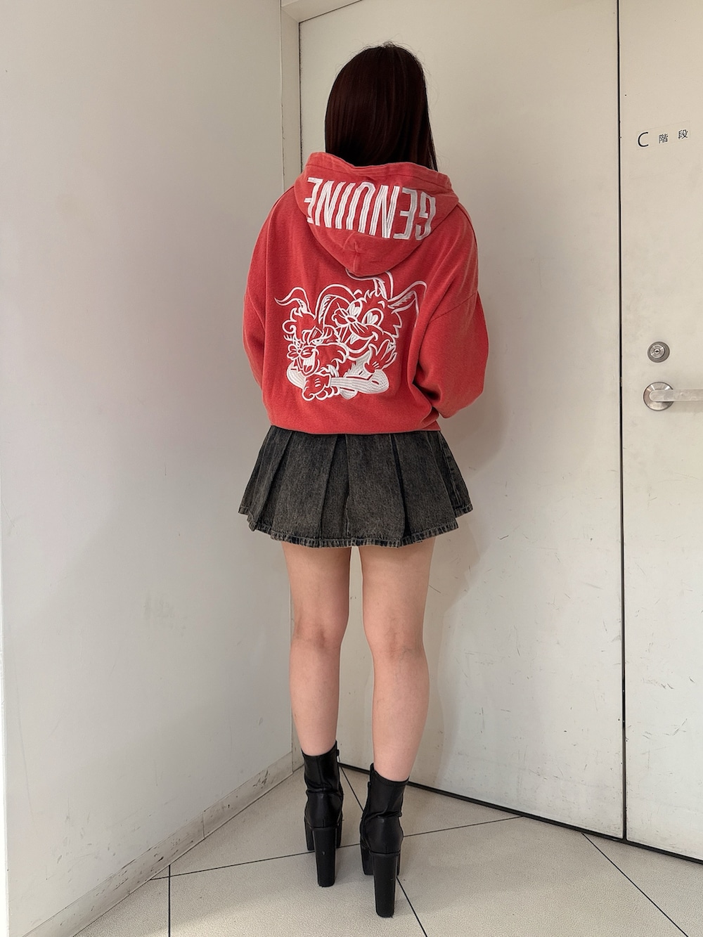 レッド系のパーカー、その他のデニムスカート、ブラック系のブーツを着用したレディースの秋コーディネートの3枚目の写真