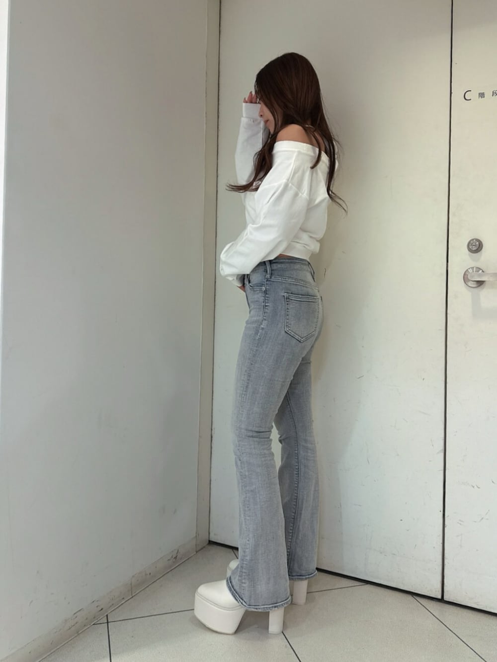 ブルー系のデニムパンツ、ホワイト系のスウェット、ホワイト系のブーツを着用したレディースの夏コーディネートの2枚目の写真