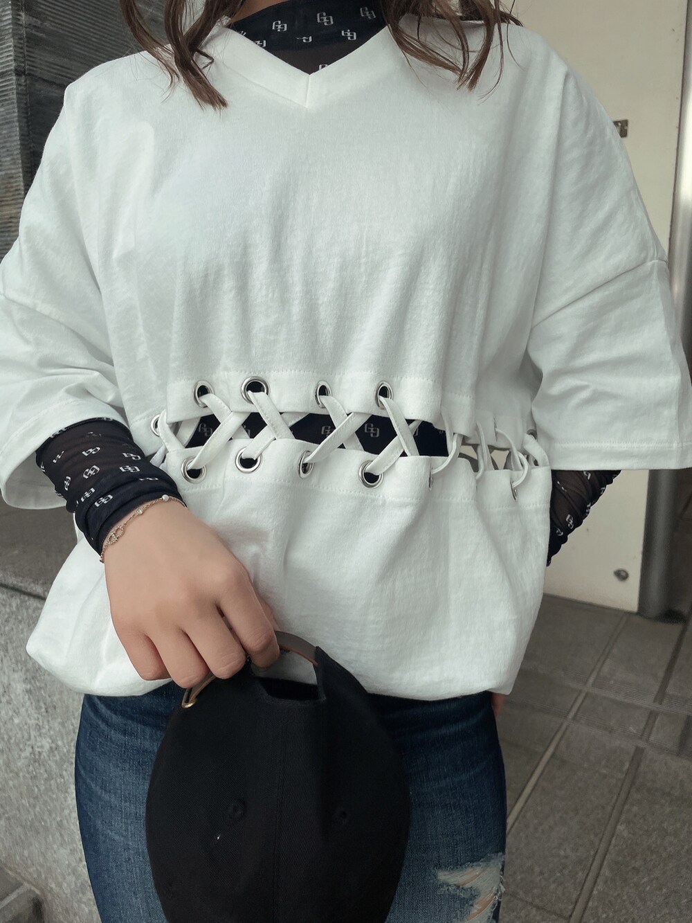 ブルー系のデニムパンツ、ブラック系のパンプス、ブラック系のTシャツ/カットソーを着用したレディースの春コーディネートの6枚目の写真