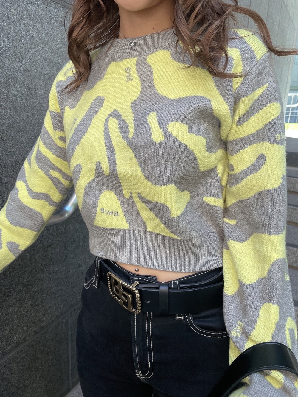 グレー系のニット/セーター、ブラック系のダウンジャケット/コート、ブラック系のデニムパンツを着用したレディースの秋コーディネートの7枚目の写真