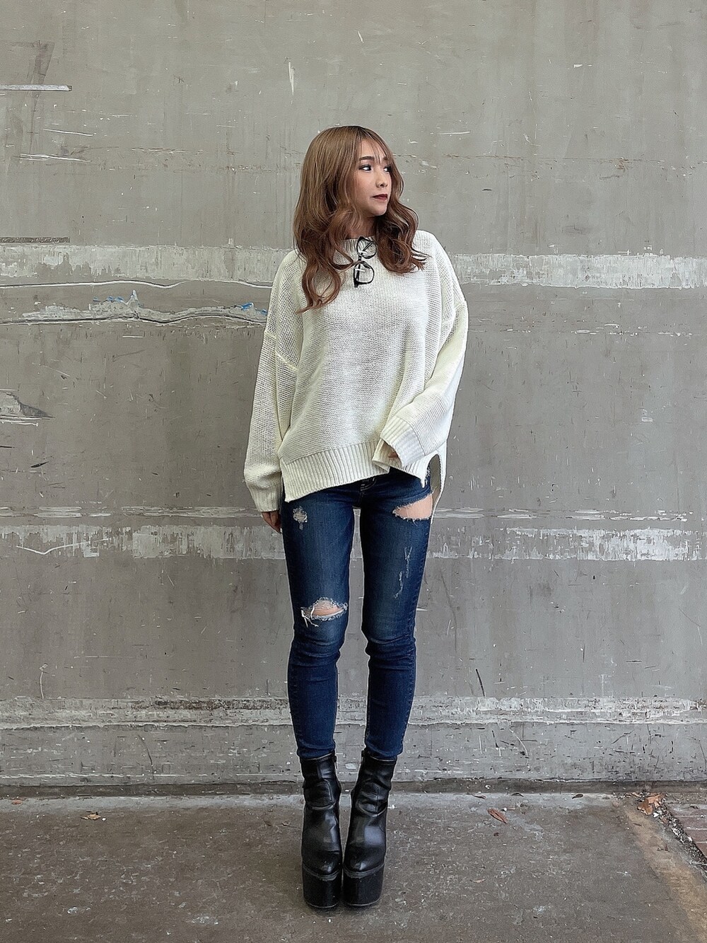 ホワイト系のニット/セーター、ブルー系のデニムパンツ、ブラック系のブーツを着用したレディースの冬コーディネートの3枚目の写真