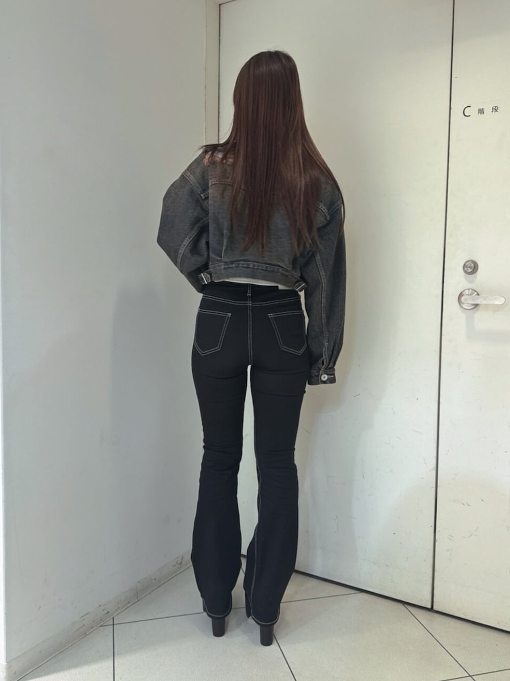 ブラック系のデニムパンツ、ブラック系のブーツ、ブルー系のデニムジャケットを着用したレディースの夏コーディネートの3枚目の写真
