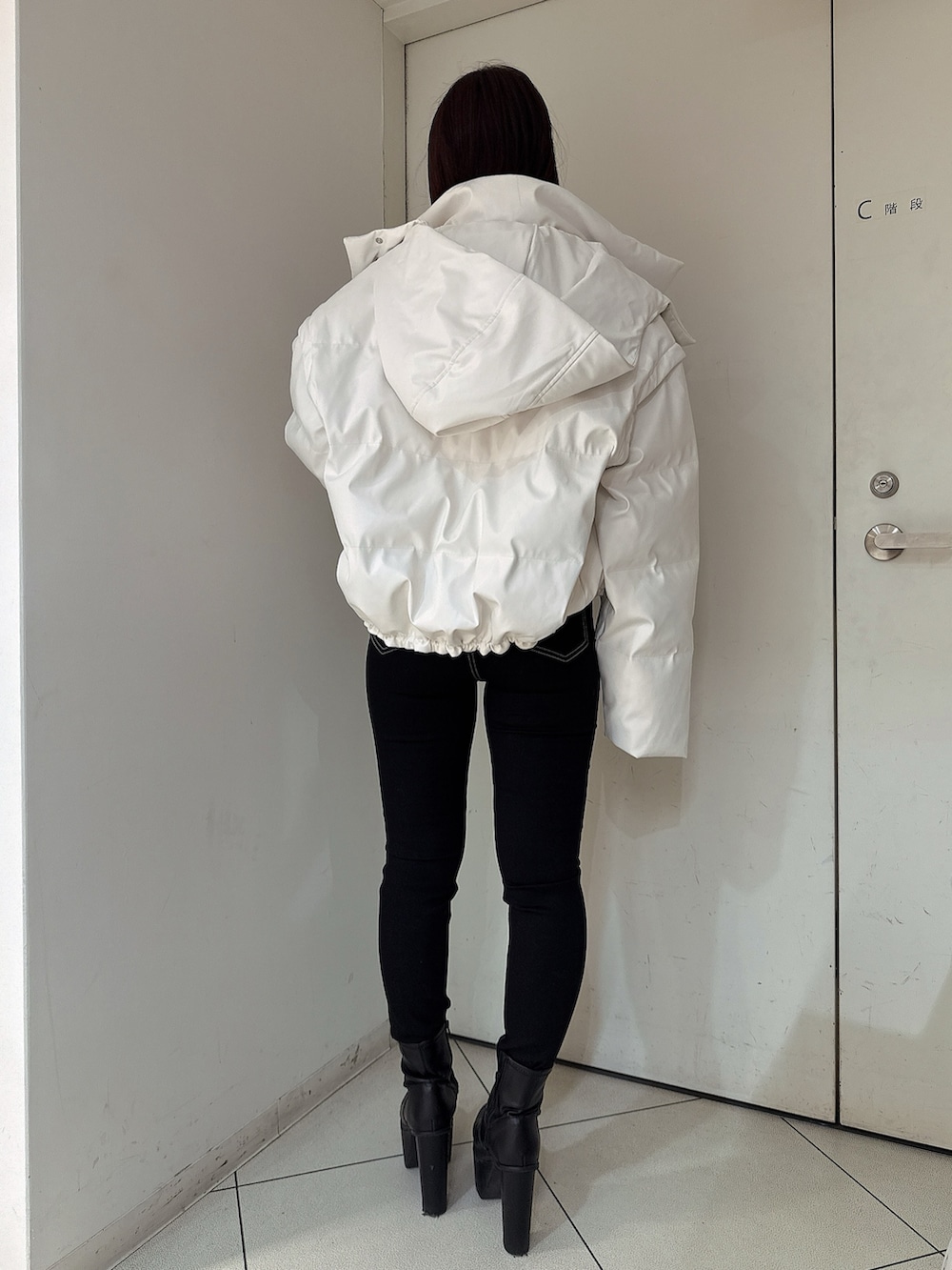 ブラック系のデニムパンツ、ブラック系のブーツ、ブラック系のニット/セーターを着用したレディースの秋コーディネートの3枚目の写真