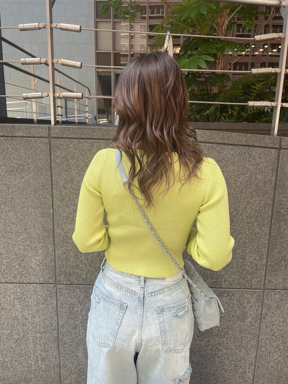 ブルー系のデニムパンツ、ホワイト系のサンダルを着用したレディースの春コーディネートの6枚目の写真