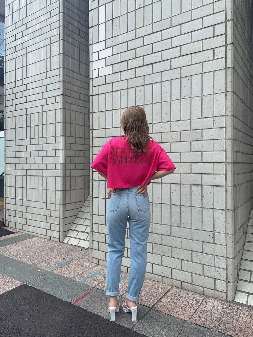 ブルー系のデニムパンツ、ホワイト系のサンダル、ピンク系のTシャツ/カットソーを着用したレディースの夏コーディネートの2枚目の写真