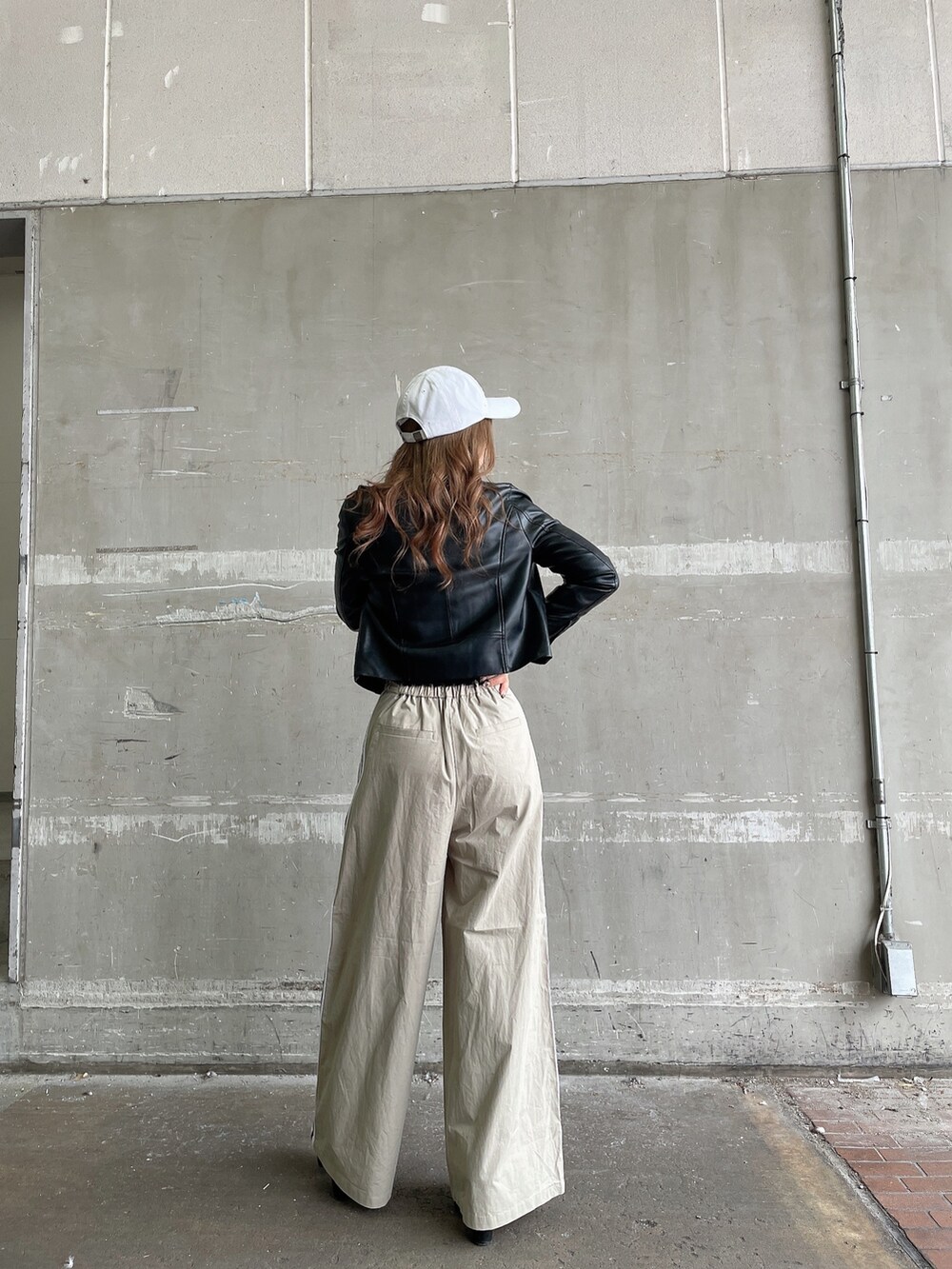 ブラック系のライダースジャケット、ベージュ系のチノパンツ、その他のニット/セーターを着用したレディースの冬コーディネートの3枚目の写真