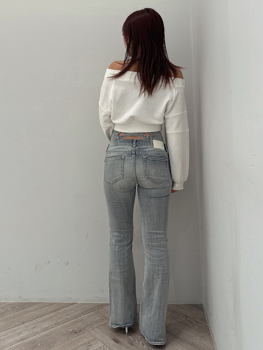 ブルー系のデニムパンツ、ホワイト系のパンプス、ホワイト系のスウェットを着用したレディースの冬コーディネートの3枚目の写真