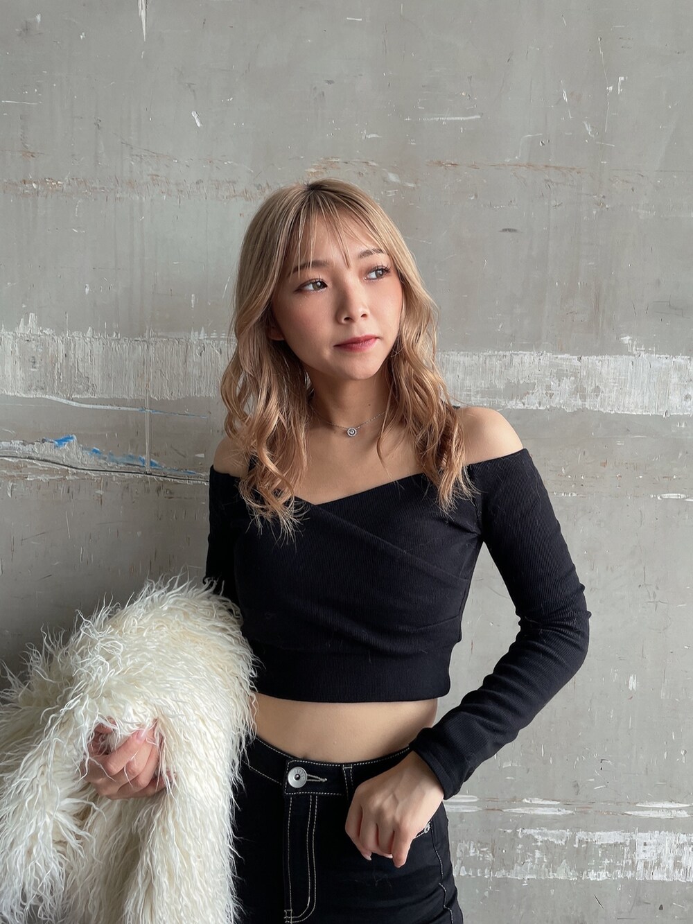 ブラック系のTシャツ/カットソー、ホワイト系のベスト、ブラック系のデニムパンツを着用したレディースの秋コーディネートの5枚目の写真