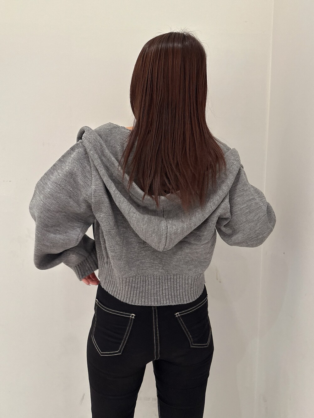 グレー系のパーカー、ブラック系のキャミソール、ブラック系のデニムパンツを着用したレディースの夏コーディネートの5枚目の写真