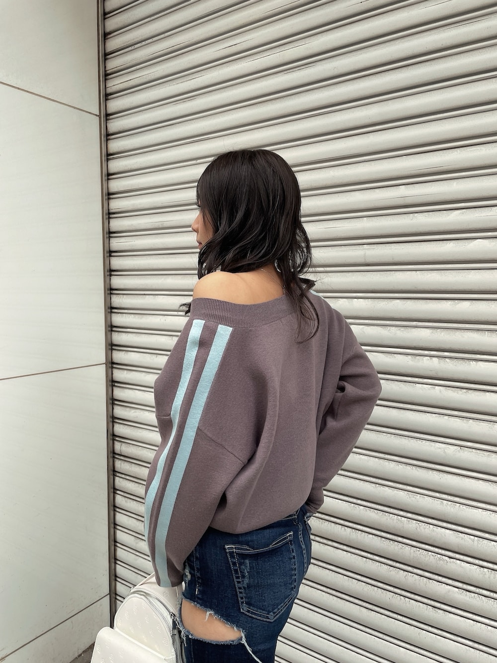 グレー系のニット/セーター、ブルー系のデニムパンツ、ブラック系のブーツを着用したレディースの冬コーディネートの4枚目の写真