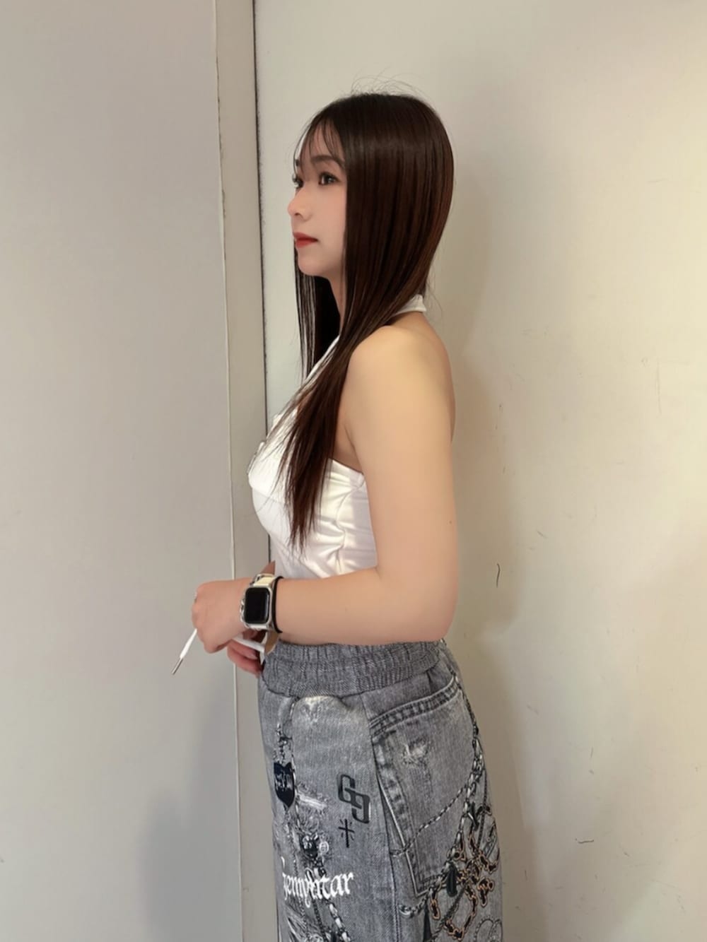 ブラック系のサンダル、ブラック系のデニムパンツ、ホワイト系のチューブトップを着用したレディースの夏コーディネートの5枚目の写真