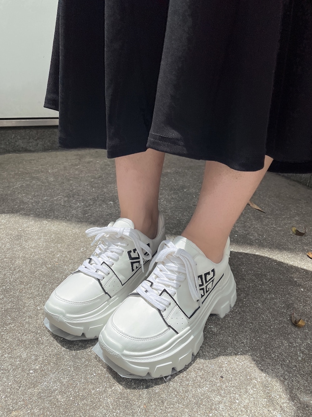 ブラック系のワンピース、ホワイト系のスニーカー、ホワイト系のTシャツ/カットソーを着用したレディースの夏コーディネートの7枚目の写真