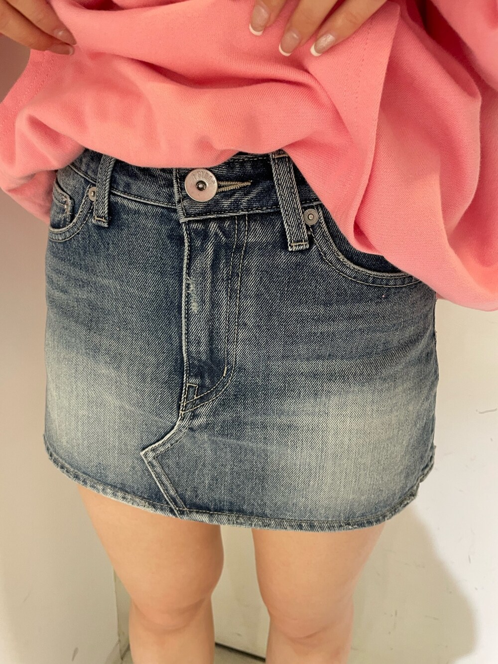 ピンク系のパーカー、ブルー系のデニムスカートを着用したレディースの冬コーディネートの7枚目の写真