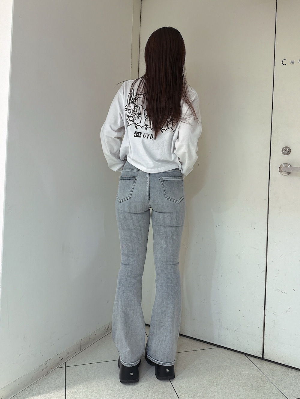 ブルー系のデニムパンツ、ホワイト系のTシャツ/カットソー、ブラック系のサンダルを着用したレディースの春コーディネートの3枚目の写真