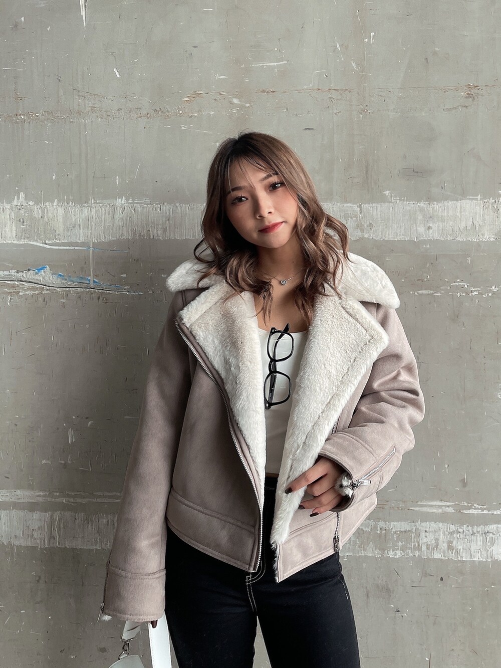 ベージュ系のムートンコート、ホワイト系のTシャツ/カットソー、ホワイト系のハンドバッグを着用したレディースの秋コーディネートの4枚目の写真