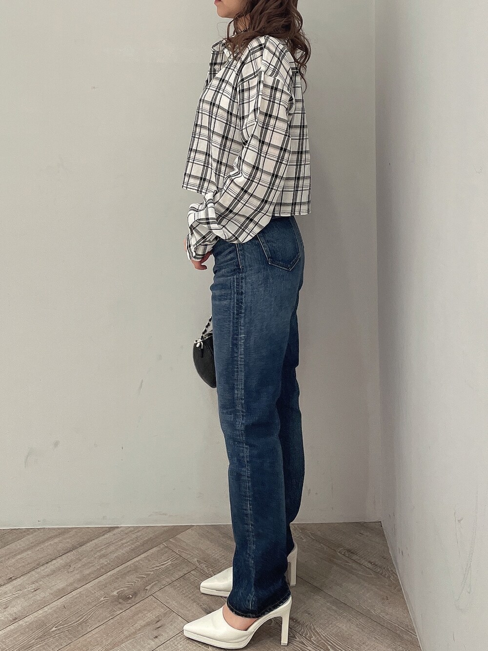 ホワイト系のシャツ/ブラウス、ブルー系のデニムパンツ、ブラック系のハンドバッグを着用したレディースの春コーディネートの2枚目の写真