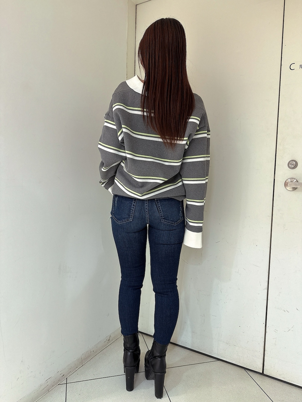 ブラック系のブーツ、ブルー系のデニムパンツ、グレー系のニット/セーターを着用したレディースの冬コーディネートの3枚目の写真