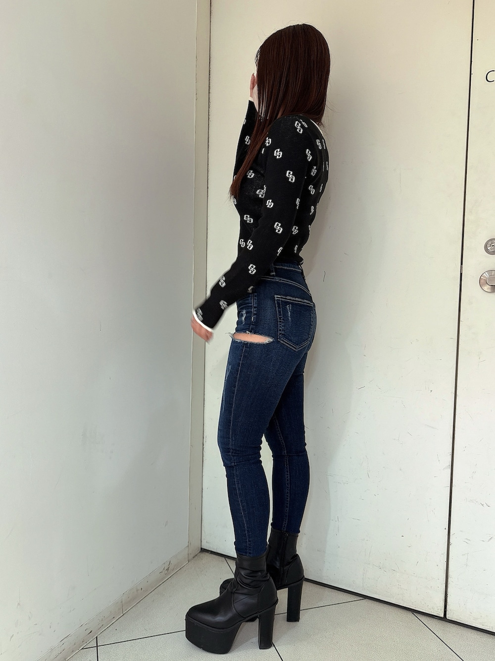 ブラック系のブーツ、ブルー系のデニムパンツ、ブラック系のニット/セーターを着用したレディースの冬コーディネートの2枚目の写真