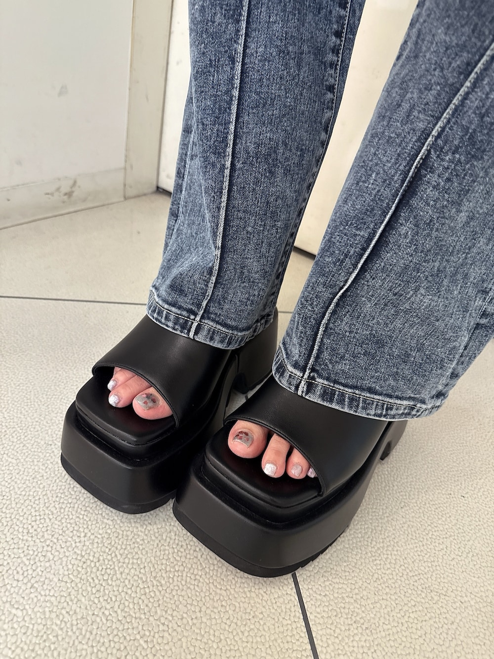 ブラック系のパーカー、ホワイト系のハンドバッグ、ブラック系のサロペット/オーバーオールを着用したレディースの春コーディネートの10枚目の写真