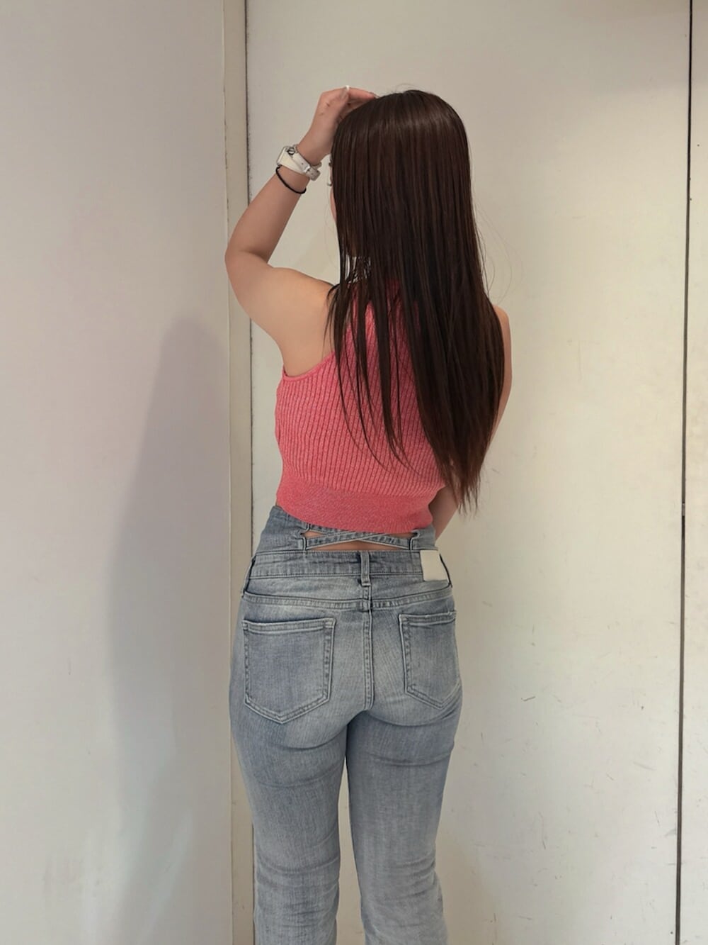 ブルー系のデニムパンツ、ホワイト系のサンダル、ピンク系のタンクトップを着用したレディースの夏コーディネートの6枚目の写真