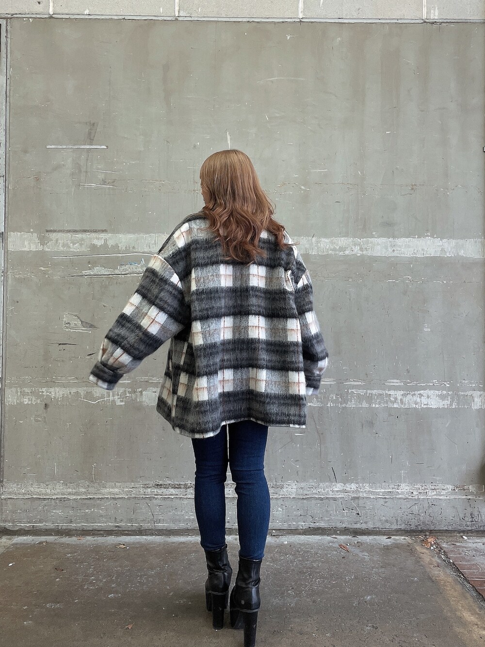 ホワイト系のニット/セーター、ブルー系のデニムパンツ、ブラック系のブーツを着用したレディースの冬コーディネートの2枚目の写真